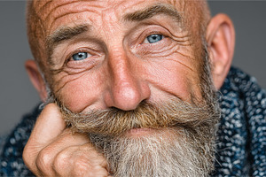 Senior man with beard and blue eyes smiling in close up portrait showing charac, a Photo by AS photostudio
