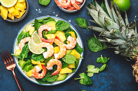 Pineapple salad with shrimps, spinach, avocado and lime on blue, a Food & Drink Photo by 5PH