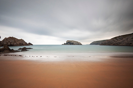 Long exposure photography on a beach containing beach, sea, and stone