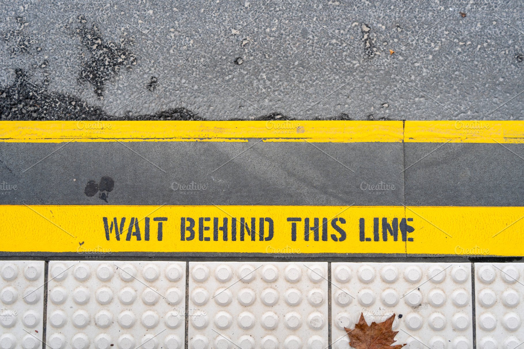 Train platform safety line with caution message on the ground, an Architecture Photo by GoodGoods