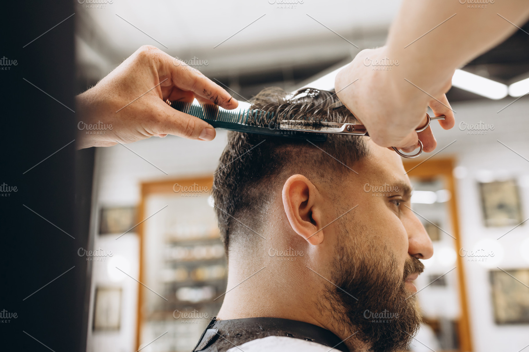 Man getting haircut at the barbershop. Professional barber at work process. Bea, a Person Photo by Volodymyr Melnyk