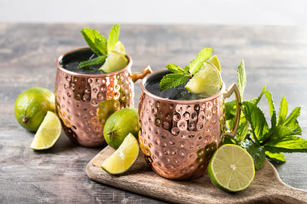 Moscow mule cocktail served with ice and lime slice on wooden table., a Food & Drink Photo by etorres69