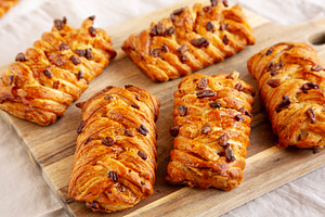 Homemade Maple Pecan Danish Pastry on a wooden board, side view., a Food & Drink Photo by LiudmylaChuhunova