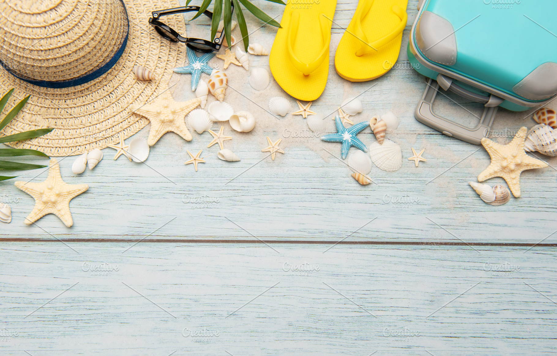 Summer accessories creating a frame on light blue wooden backgro, a Holiday Photo by Olena Rudo