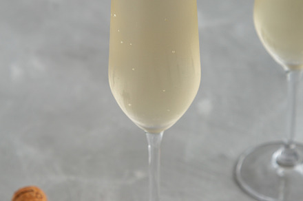 Cold Bubbly Champagne in a Glass on a gray background, side view, a Food & Drink Photo by LiudmylaChuhunova