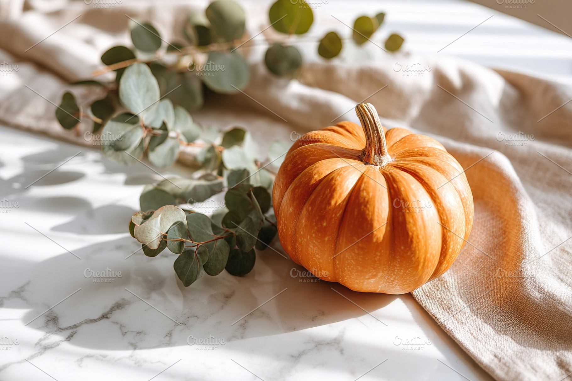 Autumn decor featuring a small pumpkin and eucalyptus on a marble table, a Holiday Photo by AlyaAnd