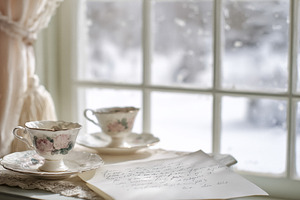 Vintage tea cups and an old handwritten letter by a winter windo, a Photo by Studio ANNA