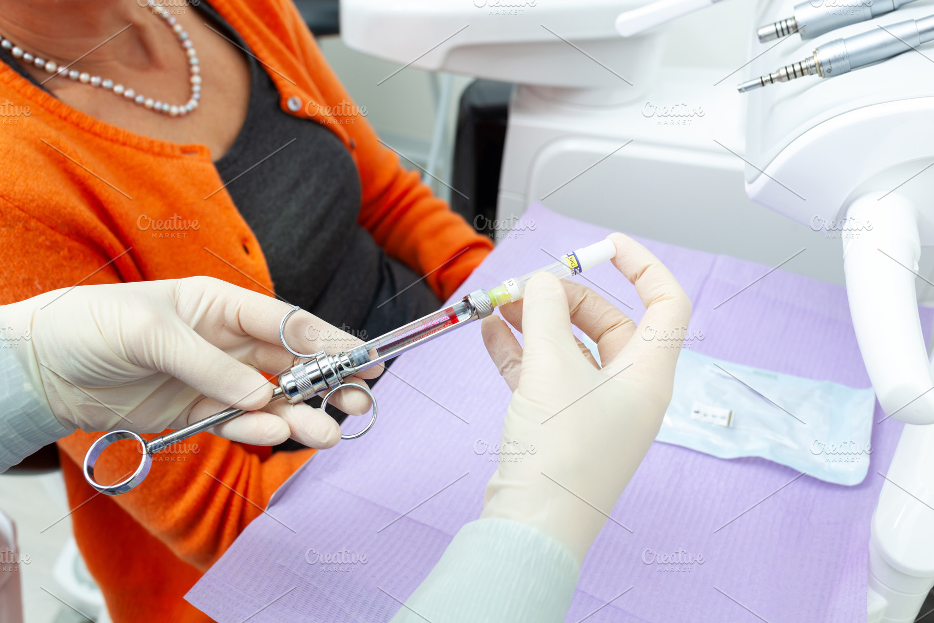 Dentist preparing anesthetic syringe for senior patient, a Photo by Antonio Gravante Market