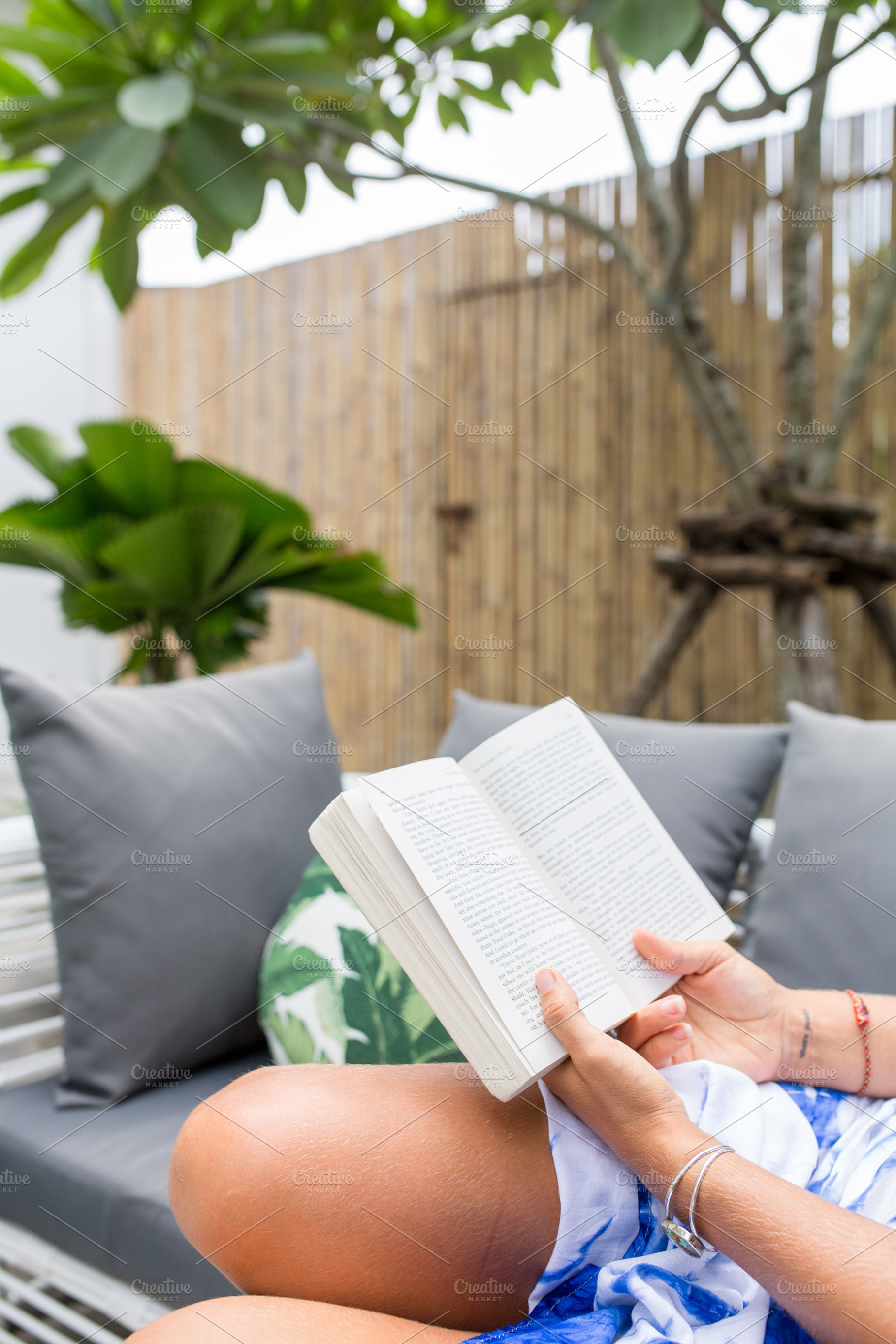 A woman holding a reading a novel, a Person Photo by Beach Babe Stock