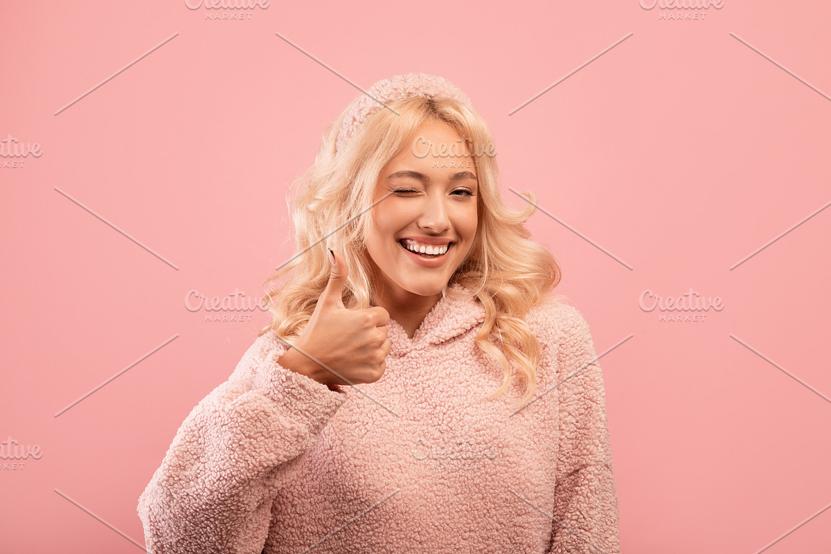 Pretty stylish lady showing thumb up, winking and smiling at camera, recommendi, a Photo by Prostock-Studio (Photo 1 of 2)