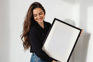 Woman holding blank picture frame, an Architecture Photo by Virgo Studio