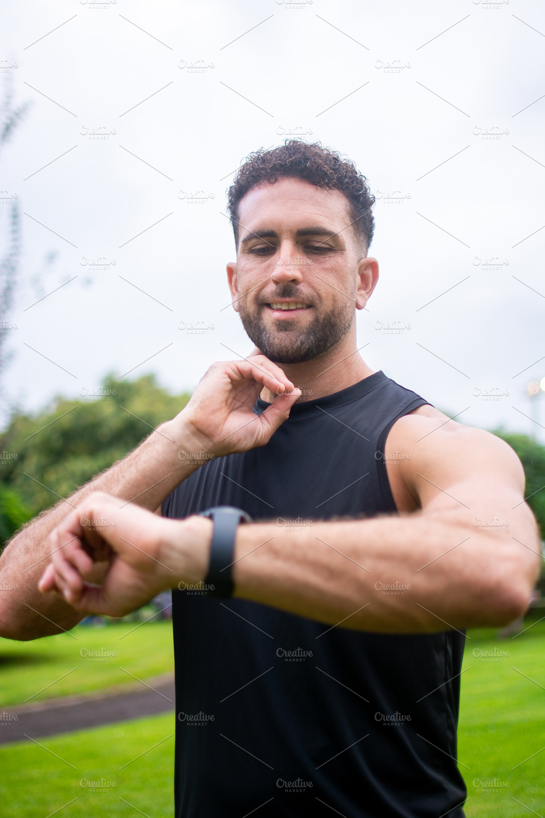 Athletic man checking smartwatch after outdoor workout in park, a Person Photo by etorres69