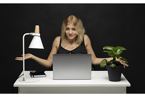 Confused young woman at desk, a Business Photo by volodymyrshtun13795