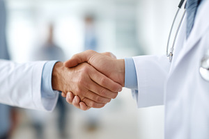 Two doctors in white coats shaking, a Health & Medical Photo by MistyDay