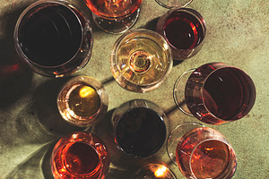 Red, white and rose wines in assortment in glasses on green back, a Food & Drink Photo by 5PH