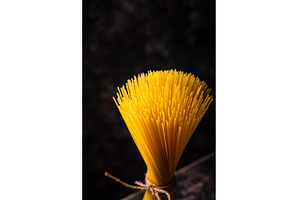 Raw uncooked sspaghetti on dark, a Food & Drink Photo by Yulia Furman