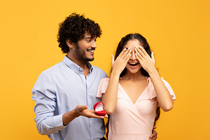 Amazing surprise on St Valentine's Day. Loving indian man making proposal with, a Photo by Prostock-Studio