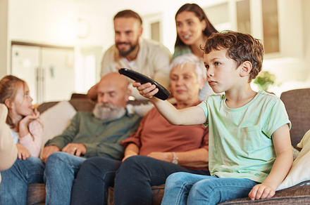 Grandparents, family tv and children in a home living room streaming a web series together. Senior people, kids and television remote watching a video on a lounge couch with a child film and movie, a Photo by Peopleimages.com