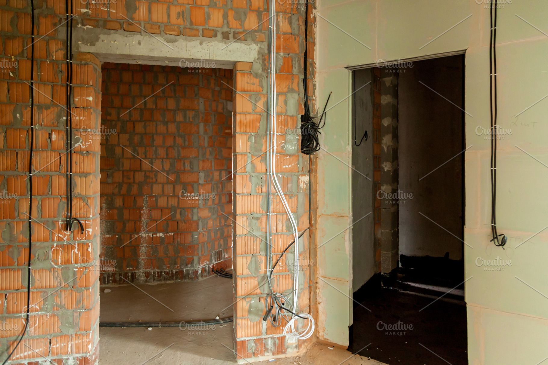 Apartment interior under renovation with exposed brick walls, an Industrial Photo by Photostock