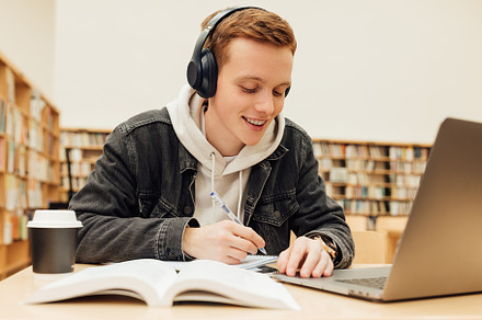 Smiling college student at table, a School & Education Photo by Artem Varnitsin