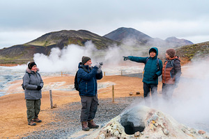 Mature travelers walking along a marked path through geothermal