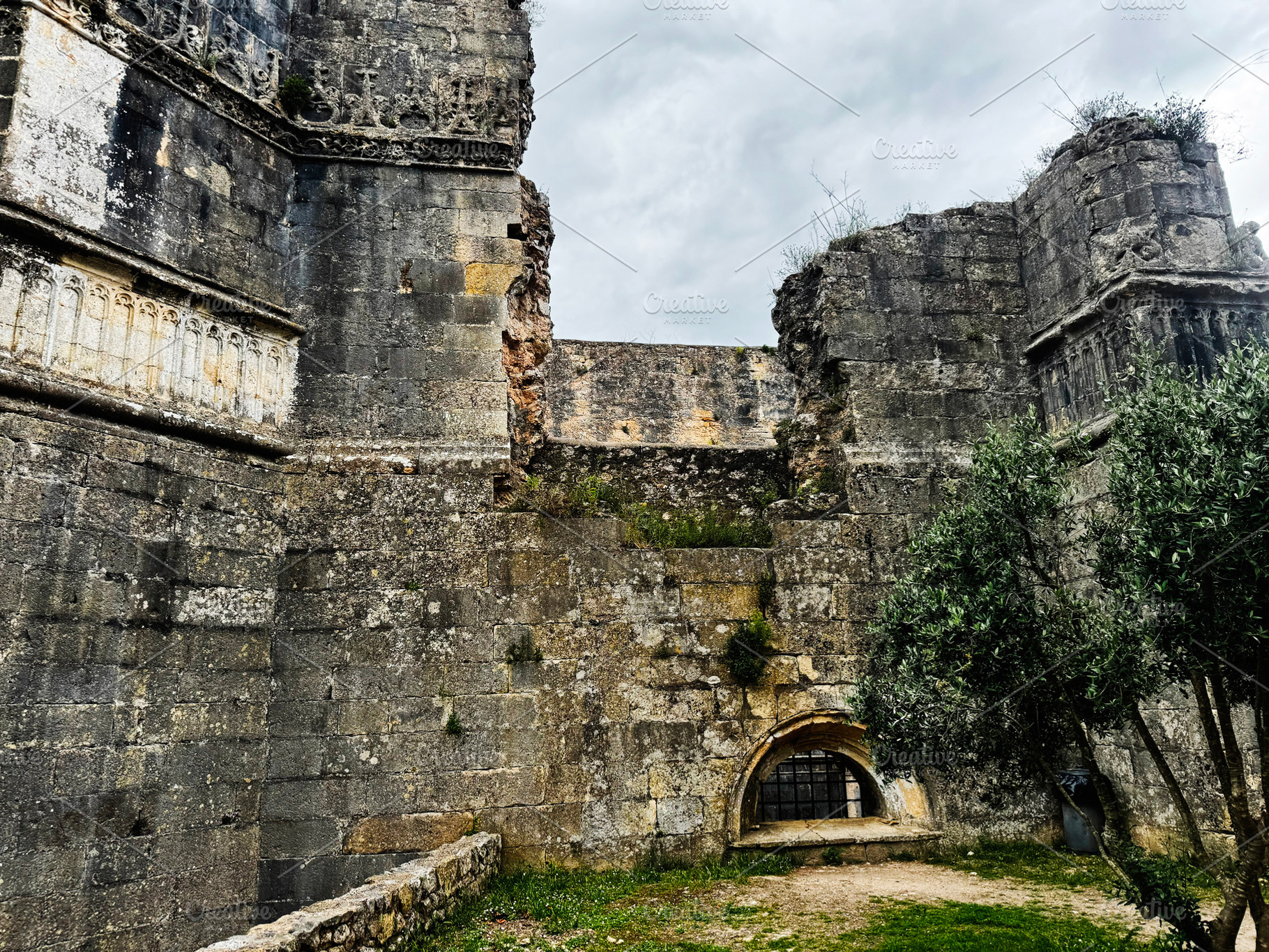 Historic ruins of Tomar Castle showcasing ancient architecture under a cloudy s, a Photo by AS photostudio