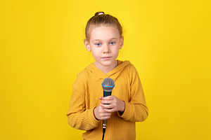 Child Holding Microphone, a Person Photo by Ales Munt