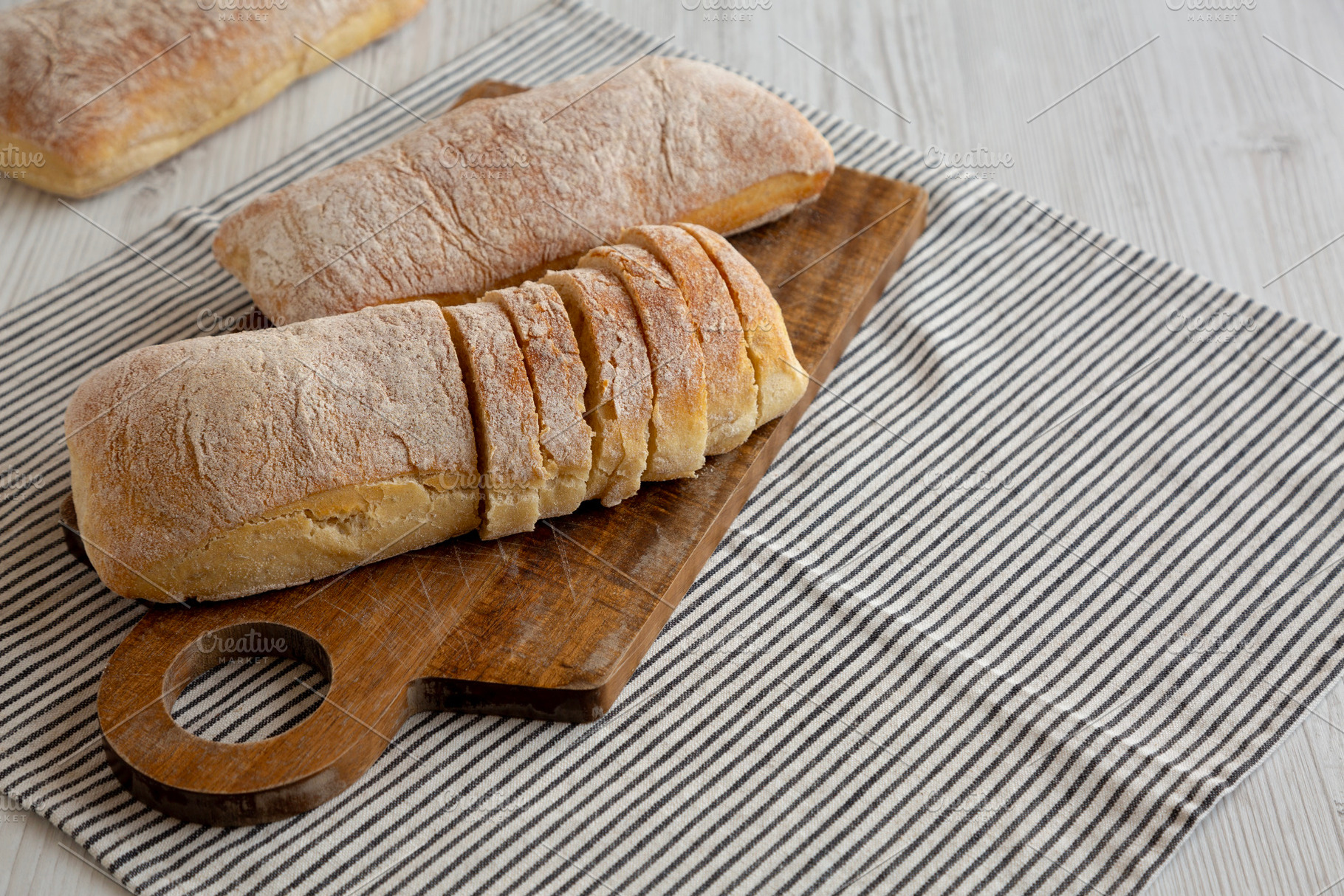 Homemade Ciabatta Bread on a wooden board, side view. Copy space, a Food & Drink Photo by LiudmylaChuhunova