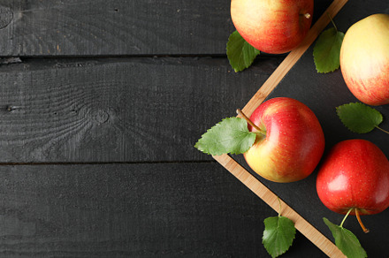 Apples and cutting board on wooden background, space for text, a Food & Drink Photo by AtlasStudio