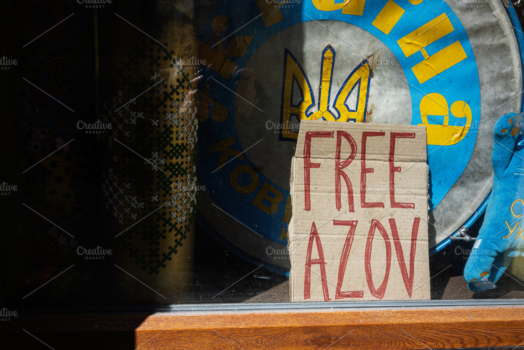 Cardboard sign Free Azov calling for support displayed outside with emblem back, a Photo by AS photostudio