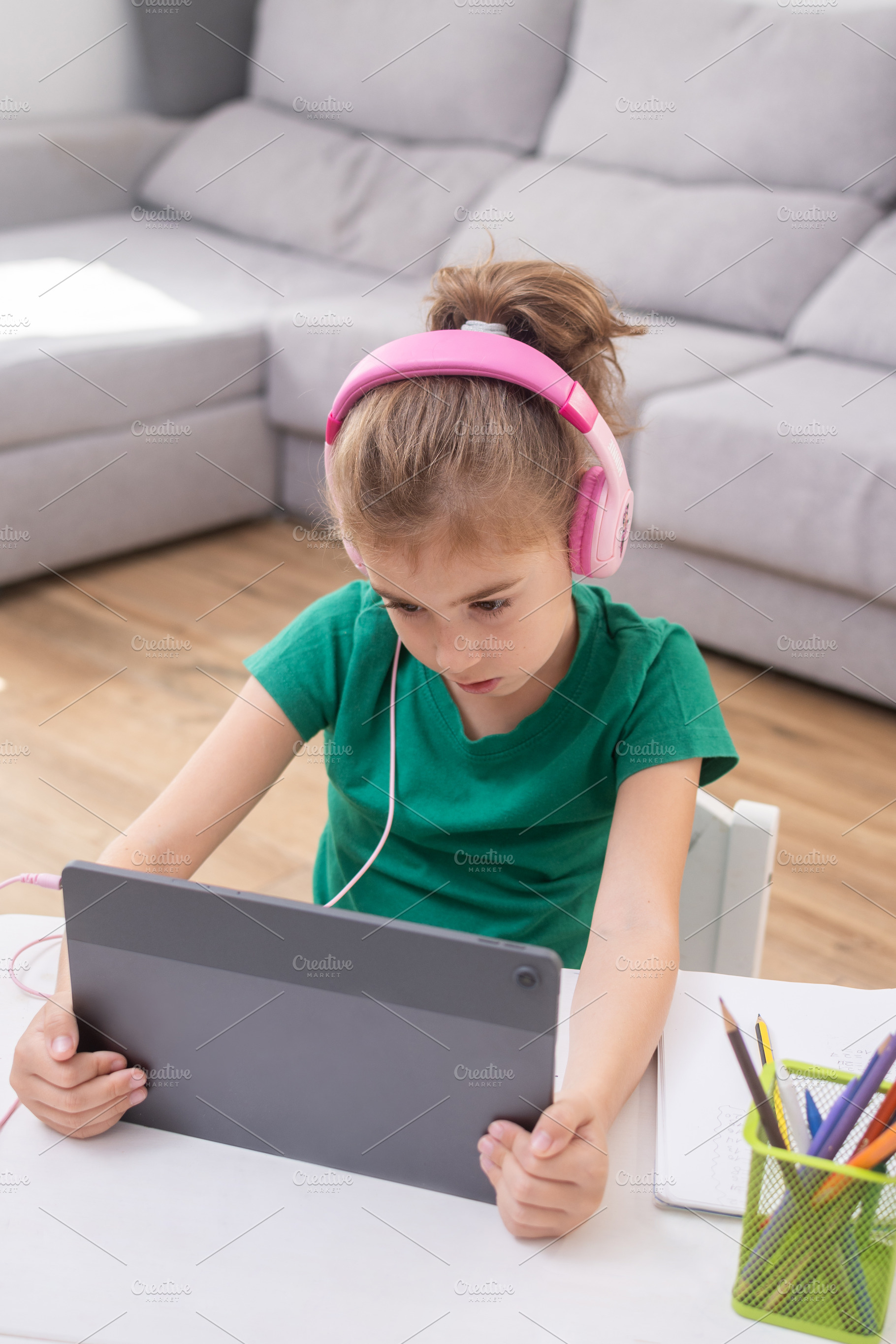Young girl wearing headphones using tablet for online learning., a Person Photo by etorres69