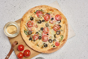 Round pizza with bacon, chicken, olives and cheese on white back, a Food & Drink Photo by ndanko
