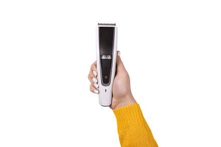 Female hand holding a modern electric hair trimmer isolated on w