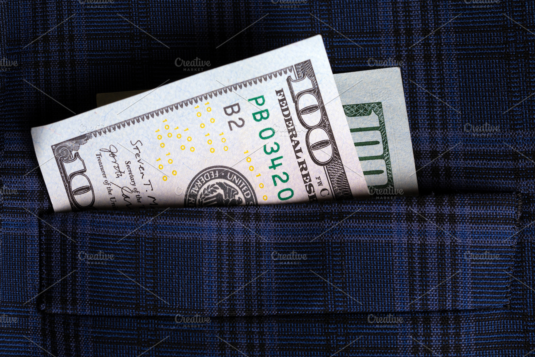Closeup of a $100 US dollar bill tucked into a blue plaid suit pocket, symboliz, a Business Photo by Ales Munt