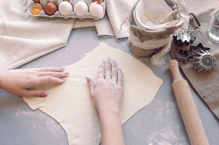 Female hands smooth the dough