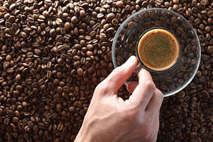 Hand taking cup of coffee to taste on coffee beans, a Food & Drink Photo by Davizro's Market