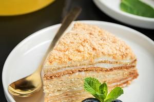 Medovik. Honey cake made from honey cakes with whipped sour cream, decorated wi, a Food & Drink Photo by Budarinphoto