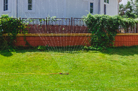 Drip fountain watering system in the garden near the house, a Nature Photo by TanaCh