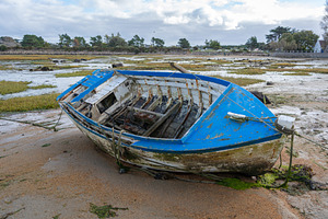 Abandoned blue boat stranded on tidal flats in Tregastel, France, a Transportation Photo by GoodGoods