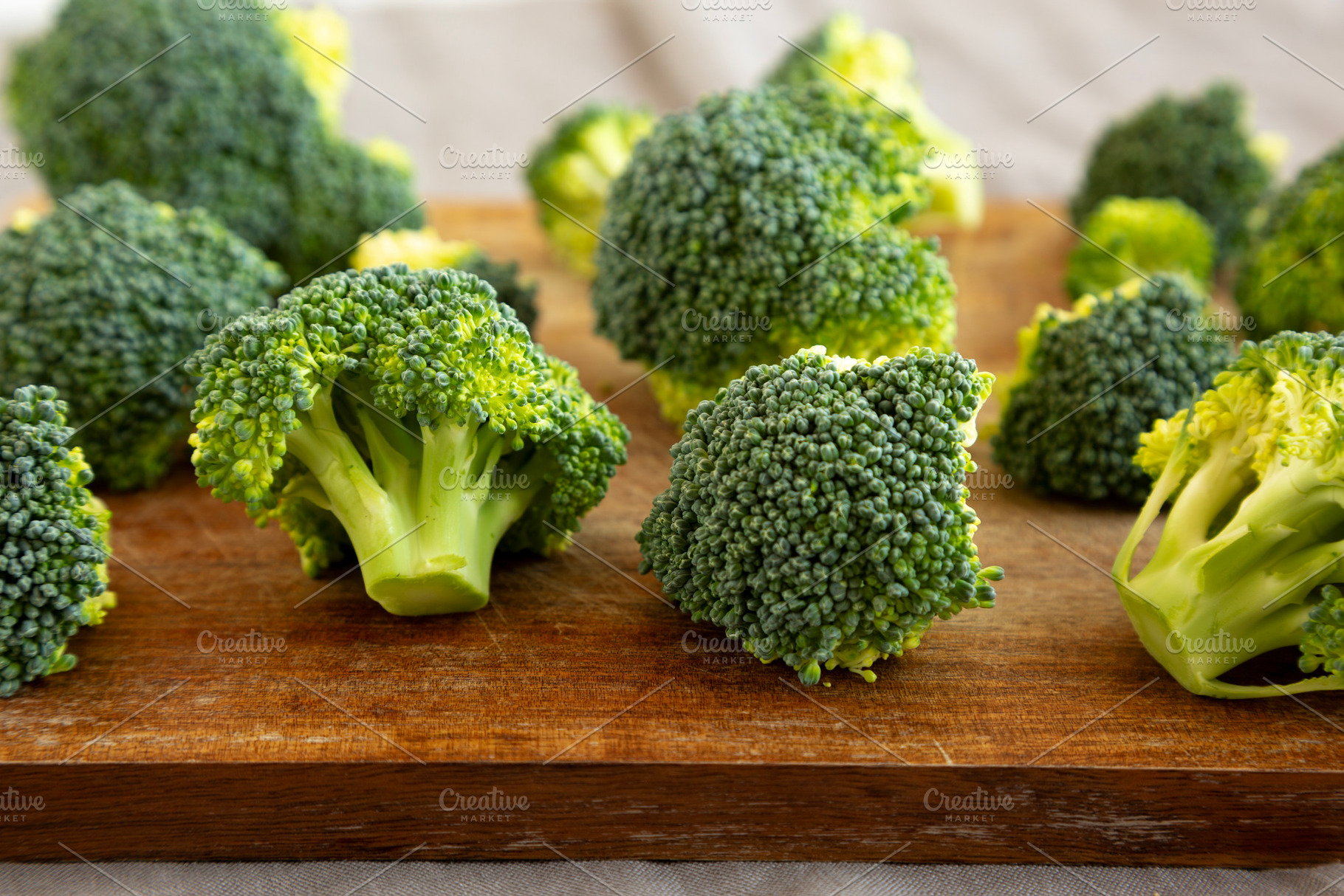 Raw Organic Green Broccoli on a Wooden Board, side view. Close-u, a Food & Drink Photo by LiudmylaChuhunova