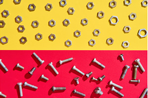 Screws and nuts on red yellow, an Industrial Photo by Gladkov photography