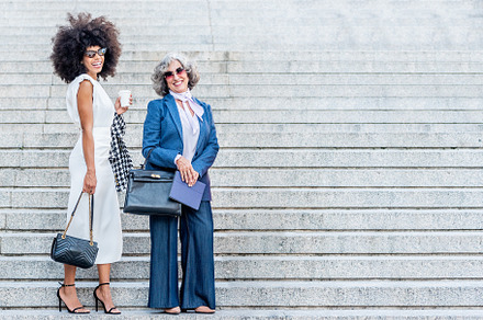 two corporate women smiling and posing well-dressed, a Business Photo by Iván Moreno STOCK PHOTO