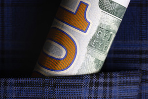 Rolled ten dollar bill tucked into a blue plaid shirt pocket, symbolizing savin, a Business Photo by Ales Munt