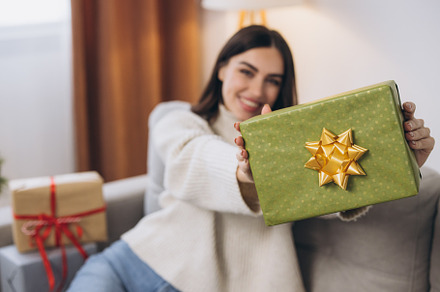 Beautiful happy woman unwrapping New Year or Christmas presents