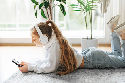 Little girl listening music lying on the floor, a Person Photo by Olena Rudo