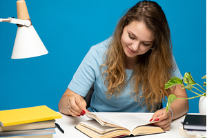 Woman reading book at desk with, a Person Photo by volodymyrshtun13795
