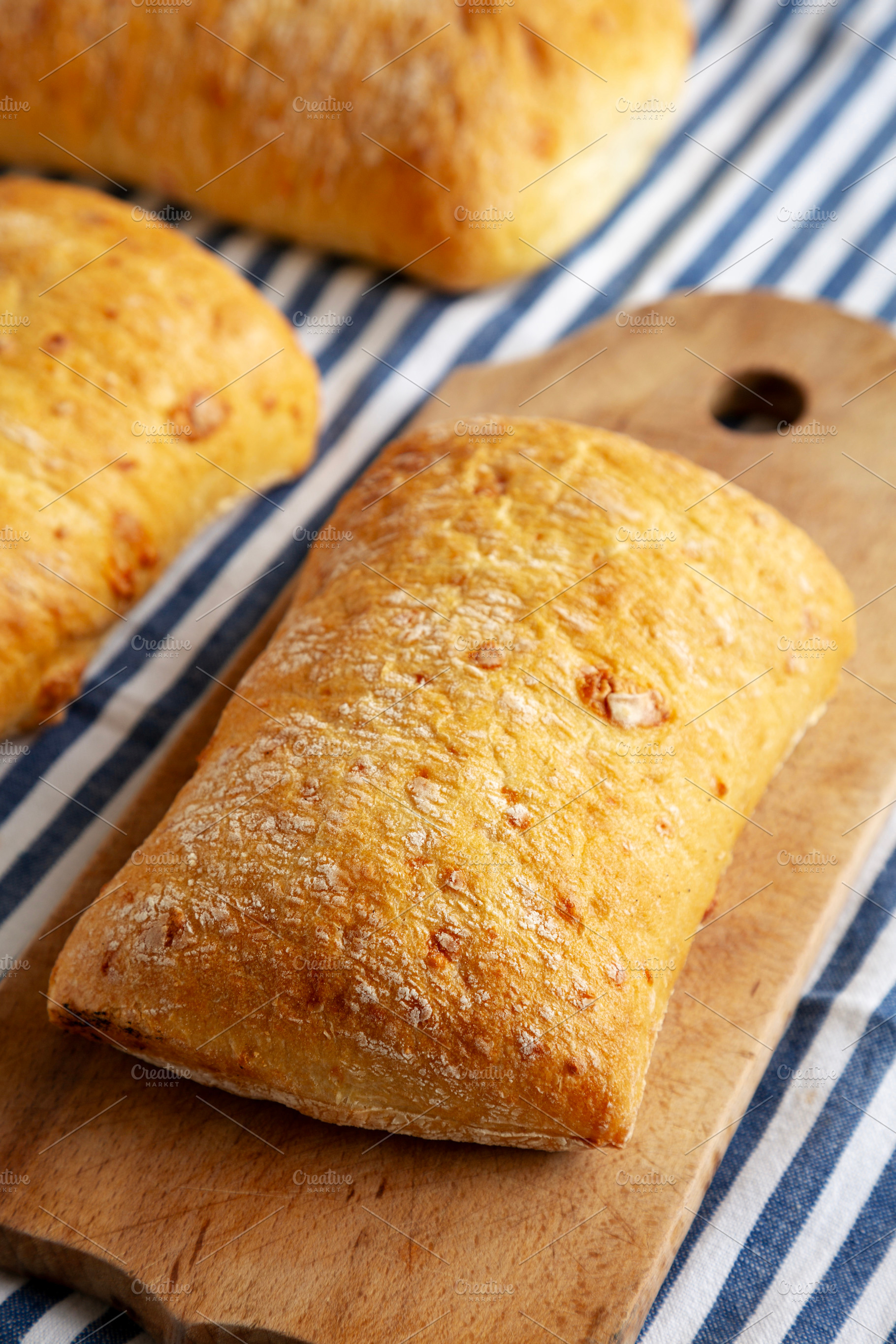 Homemade Cheese Ciabatta Bread on a Wooden Board, side view., a Food & Drink Photo by LiudmylaChuhunova