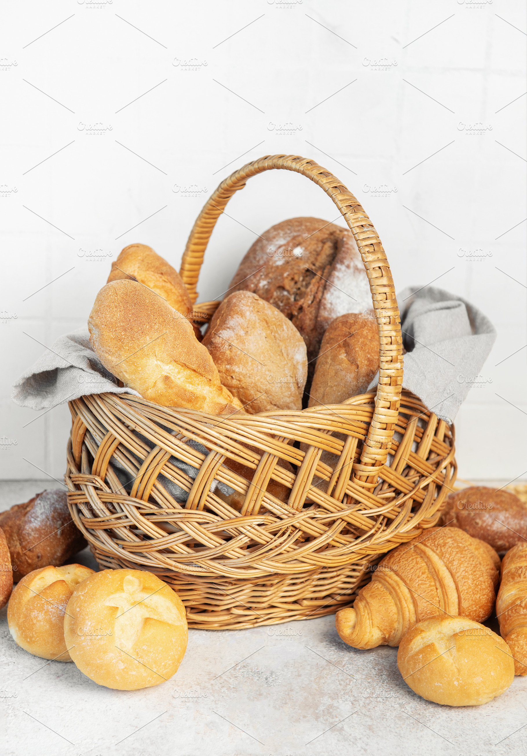 Wicker basket holding fresh bakery bread and rolls, a Food & Drink Photo by Olena Rudo