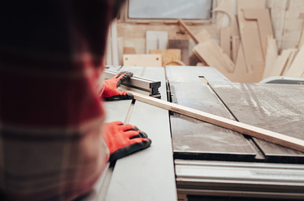 Carpenter cuts plywood on a circular, a Photo by borodai94
