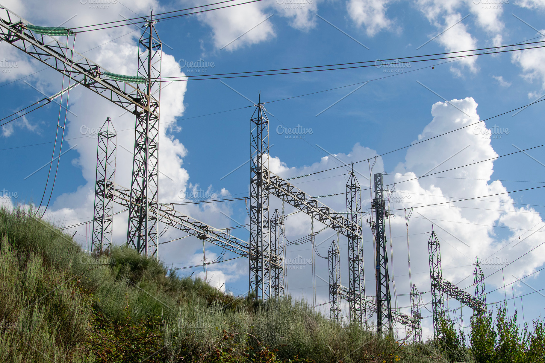 Electrical power substation on a grassy hill, an Industrial Photo by DanFLCreativo